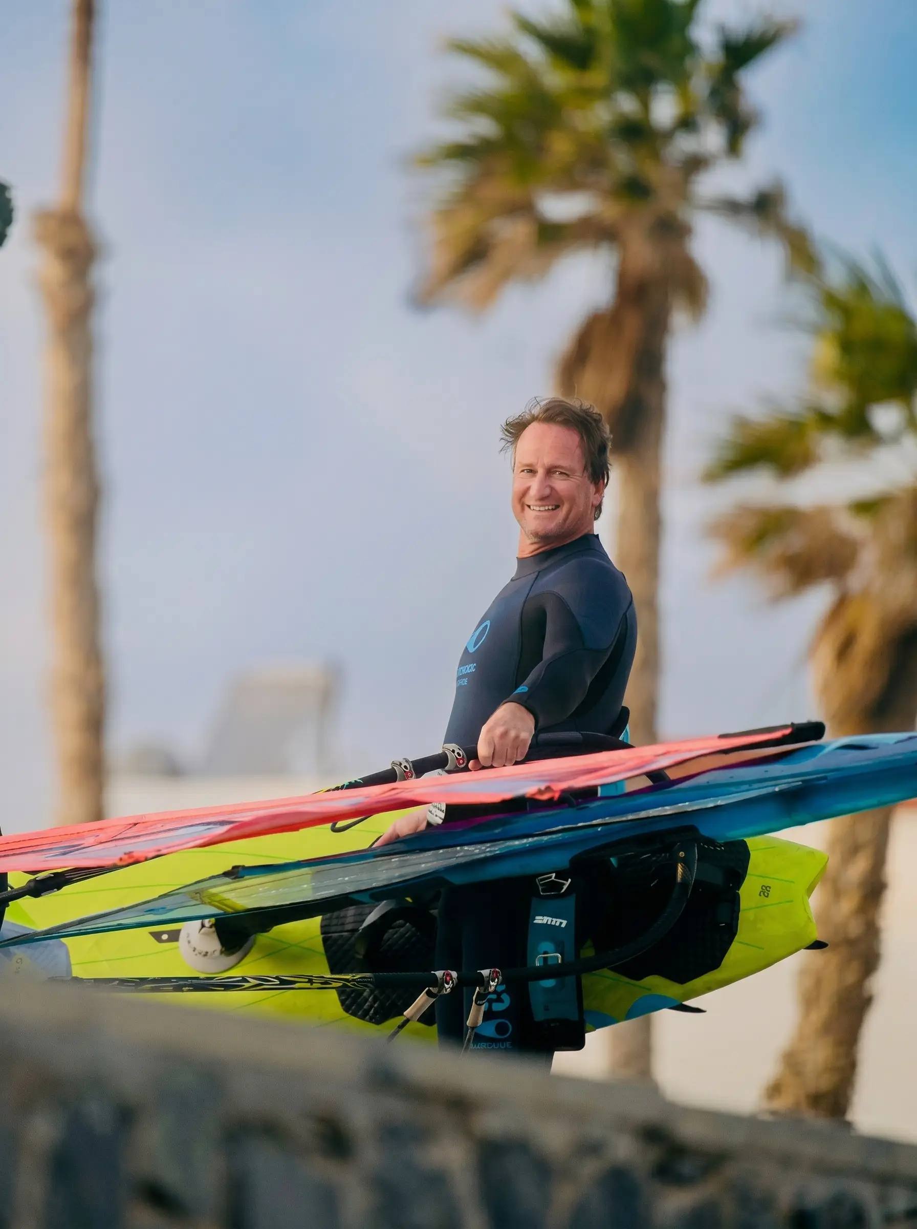 Ernst Ebner mit Windsurf-Equipment am Strand